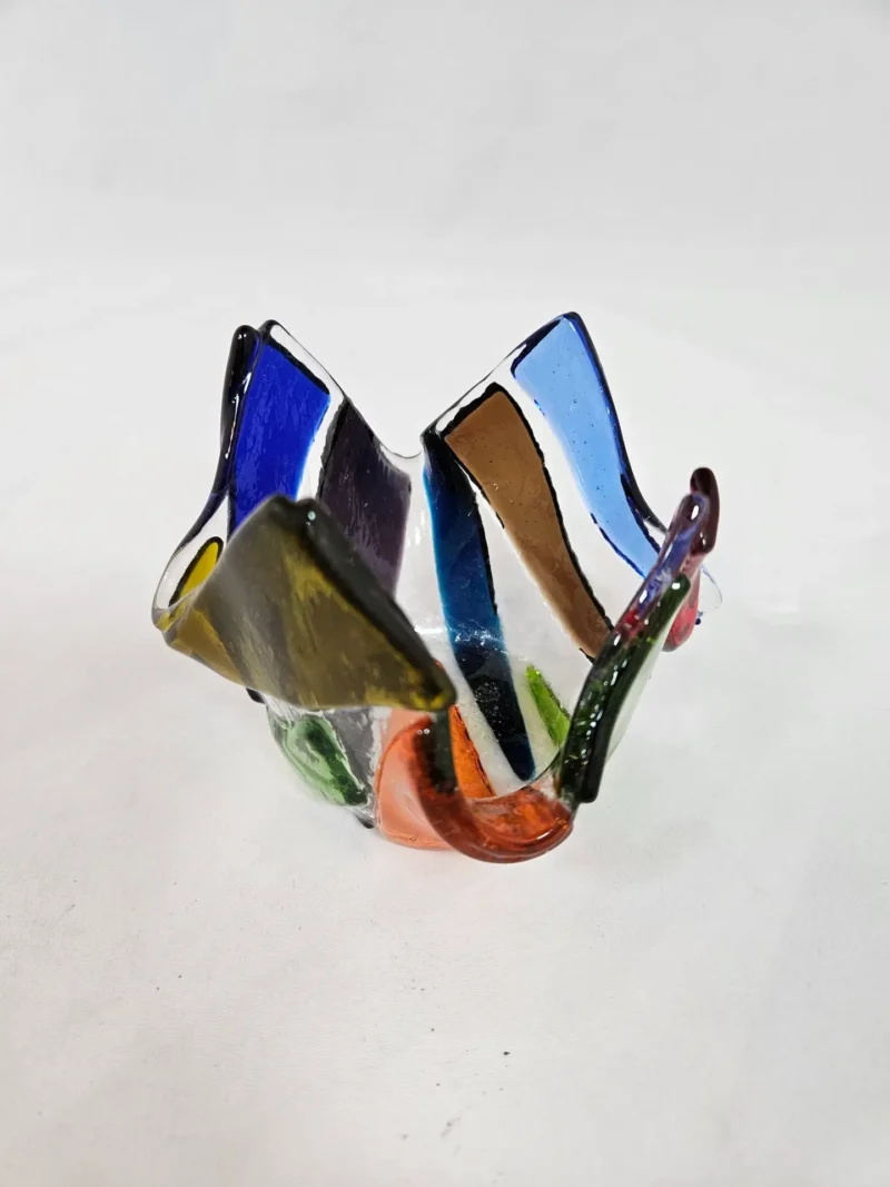 The Prism Flame is a multicolored glass art piece featuring irregular, folded shapes and translucent panels.