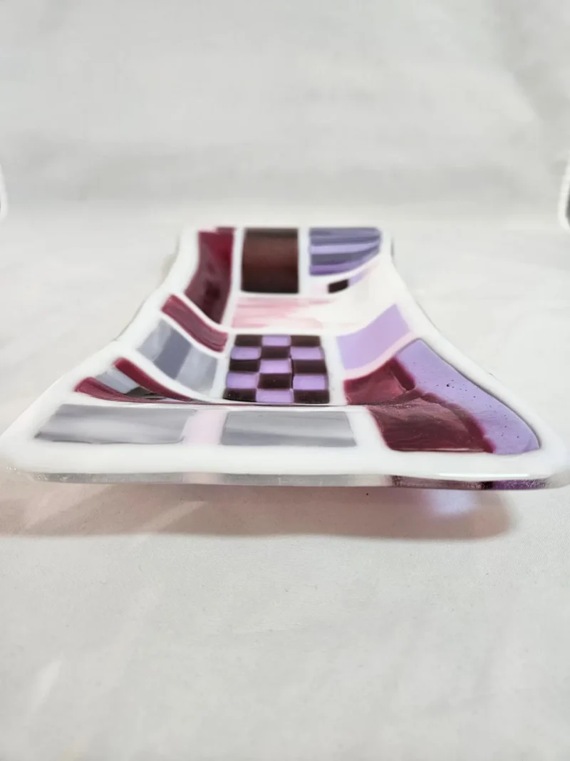 The Burgundy Brushstrokes is a rectangular glass dish featuring a checkered pattern in purple, white, and black.