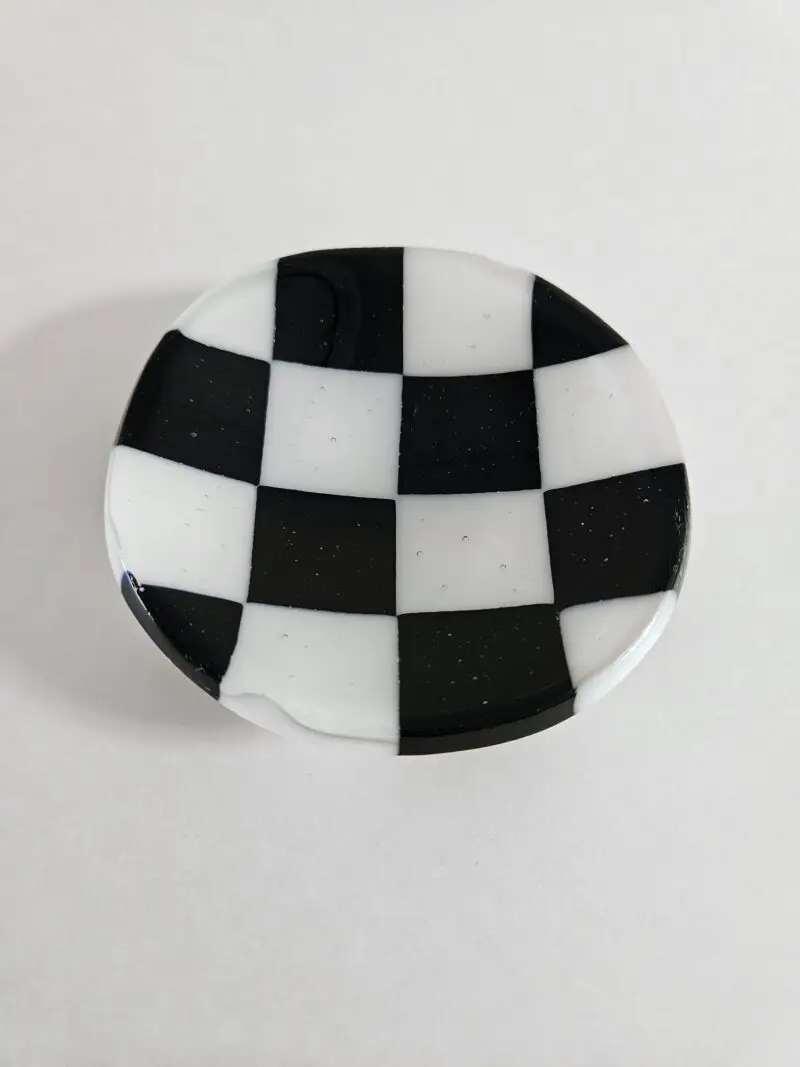 Fused glass trinket dish with black and white checkerboard pattern.